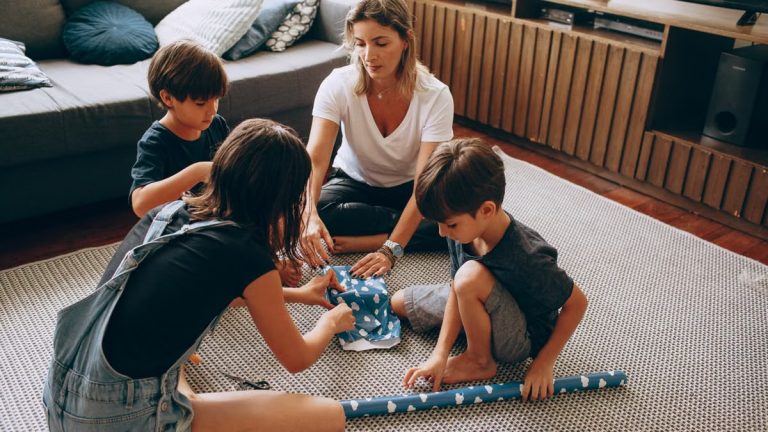 Mother and children wrapping gifts together, enjoying quality family time indoors.