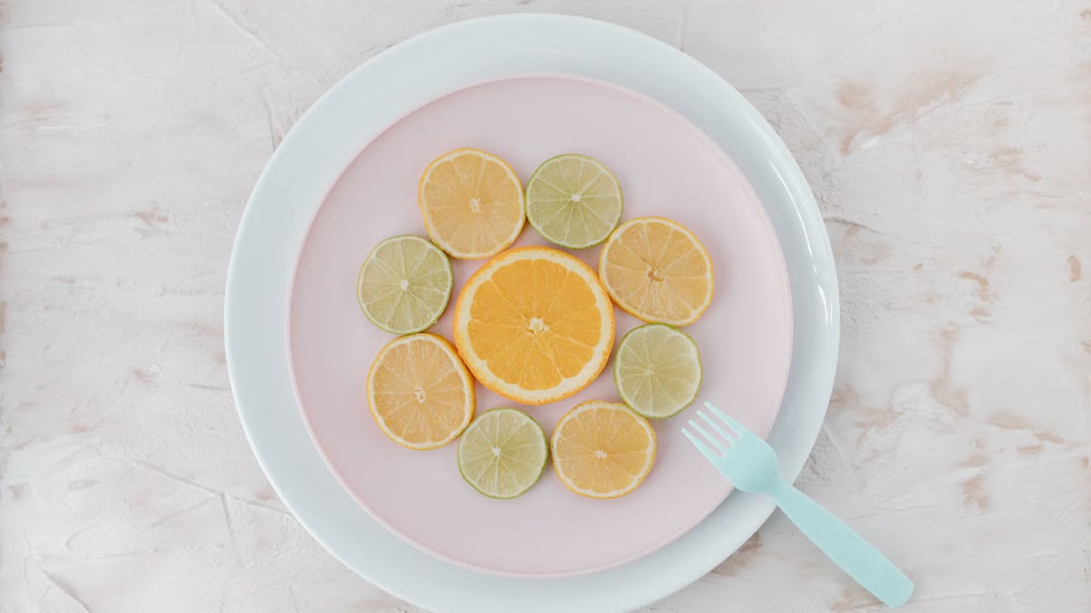 Top view of citrus slices on ceramic plates, showcasing lime and orange artistry.